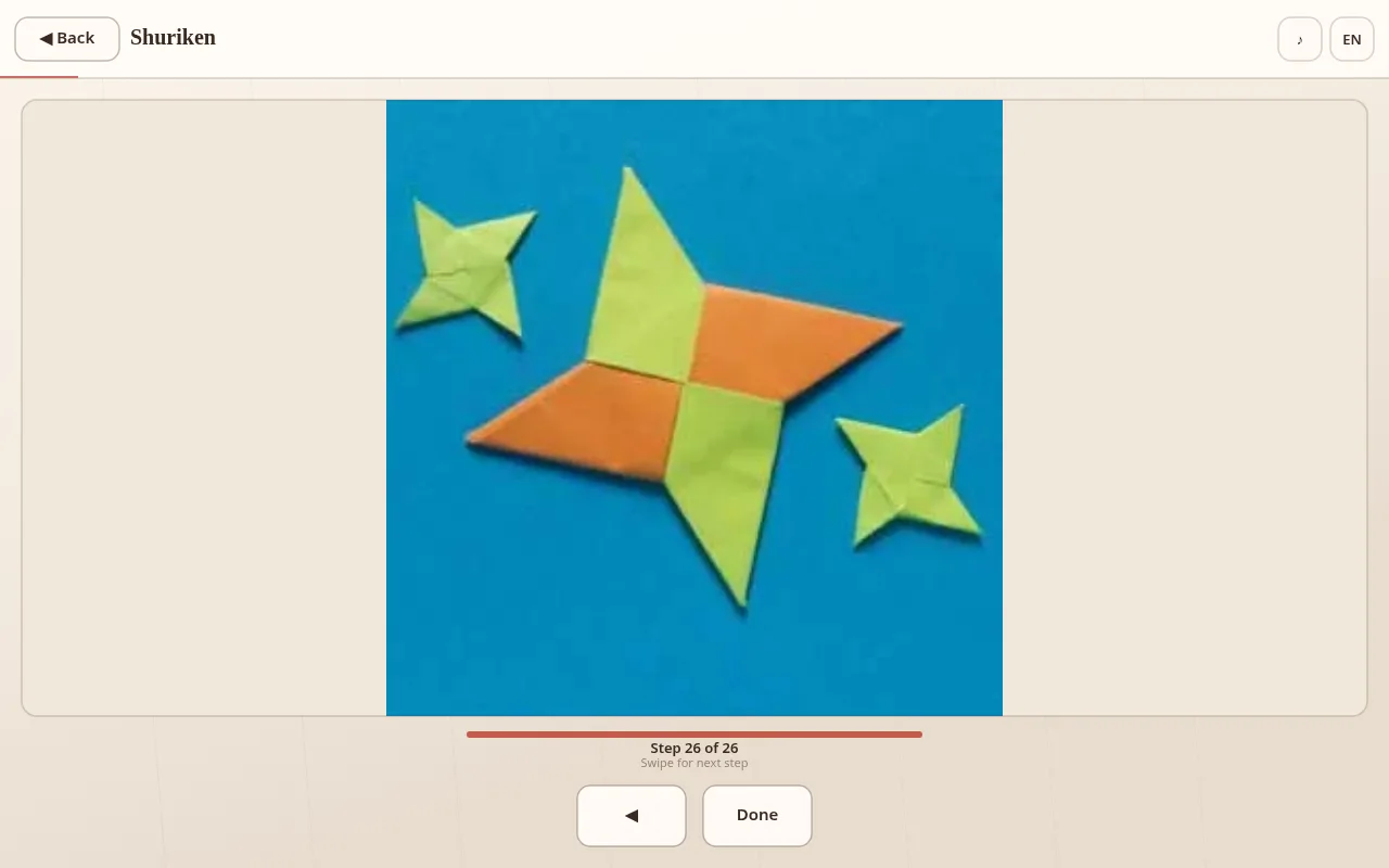 Shuriken Step 26 of 26: finished orange-and-green paper star with two smaller green stars, progress bar full, Done button at the bottom