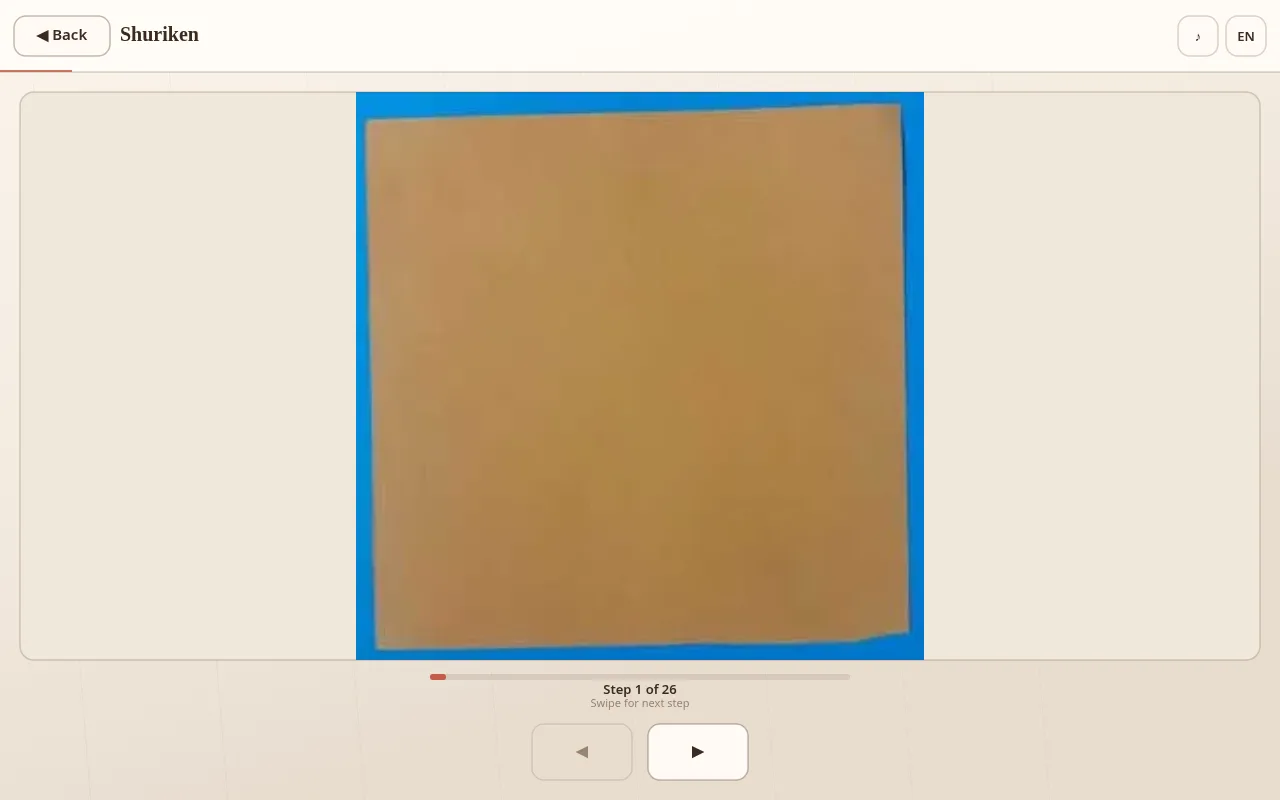 Shuriken Step 1 of 26: a flat tan square of paper on a blue surface inside the Origami Art step viewer, progress bar barely started